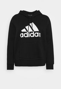 Černá mikina s kapucí z měkké tkaniny, vybavená přední klokankou a velkým bílým logem Adidas přes hruď.