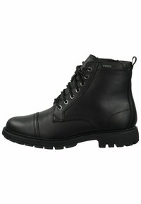 Botas de cuero negro hasta el tobillo con puntera redondeada, parte frontal con cordones, ojales de metal y una suela de goma texturizada con patrones de tracción.