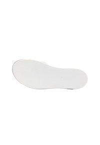 Hvid gummi sko sål med en tekstureret overflade, rund form og en lille cirkulær fordybning i midten for ekstra greb.