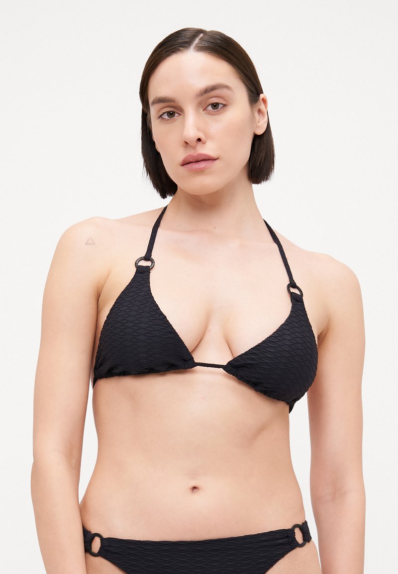 Svart bikini-sett med en strukturert, diamantformet stoff. Toppen har trekantede kopper med justerbare stropper og sirkulære detaljer.