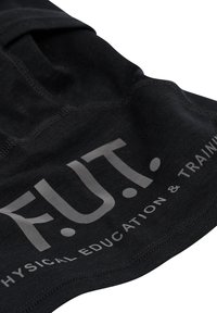 Svart tyg med "F.U.T." tryckt i stora grå bokstäver och "Physical Education & Training" i mindre grå text nedanför.