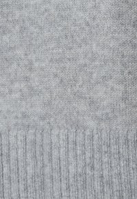 Lichtgrijze gebreide sweaterstof met een gladde textuur en een ribbelzoom. Bevat een subtiel patroon met variërende grijstinten.