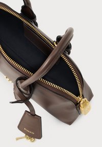 Borsa in pelle marrone con zip dorata e lucchetto, interno nero, due manici e etichetta in pelle attaccata con chiavi.