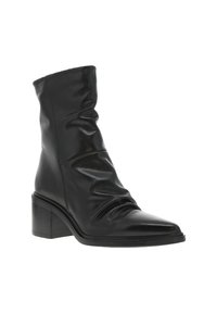 Bottines en cuir noir avec un tige souple, un bout pointu et un talon carré. Surface texturée avec des plis subtils et des détails de couture.