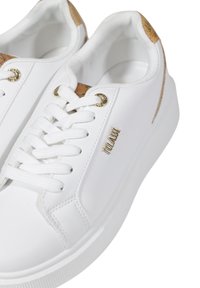 Scarpe da ginnastica bianche con sopracupo in materiale sintetico liscio, chiusura con lacci, occhielli dorati e suola in gomma texturizzata. Presentano un accento beige sul tallone.