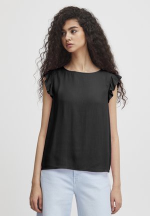 Sort ærmeløs top med flæse detaljer, struktureret stof, rund halsudskæring, løs pasform, båret med lyseblå jeans, minimalistisk design.