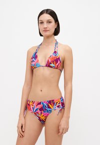 Set di bikini colorato composto da un top a triangolo e uno slip laterale regolabile con lacci, decorato con vivaci motivi di foglie tropicali in rosa, blu e viola.