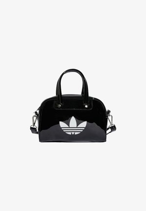 Sac à main noir brillant avec deux poignées et une bandoulière amovible, arborant un grand logo Adidas trefoil blanc à l'avant.