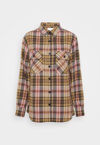 Chemise à manches longues boutonnée avec un motif à carreaux marron, rose, jaune et beige, avec deux poches poitrine boutonnées à l'avant et un col.