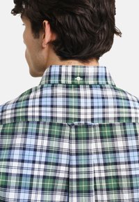Kurzarm-Hemd aus Kariert mit grün, blau und weißen Karomustern, Button-Down-Kragen und einer einzelnen Rückennaht für zusätzliche Details.