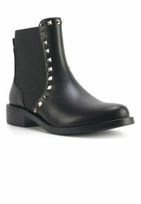 Mustad mustad nahast mustad ankle boot, gilditud nelinurksed nurgad kaunistustega jalatsite külgedel, madal plokk-kreen ja ümmargune varvas.