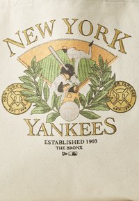 Torba typu tote z płótna z grafiką vintage New York Yankees w kolorach zielonym, złotym i czarnym, z elementami projektowymi baseballu i liści.