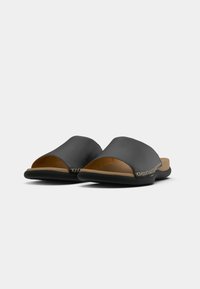 Černé kožené sandály na klínku s otevřenou špičkou, mírně zvýšenou zadní částí a béžovým prošíváním na horním okraji. Plochá podešev.