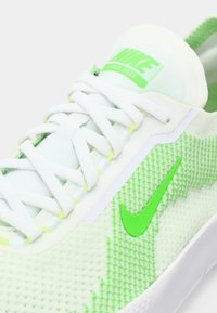 Baskets vertes et blanches avec dessus en mesh, motif texturé, lacets blancs et logo Nike vert. Design respirant pour le confort.
