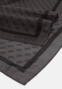 Écharpe noire avec un motif de logo répété et un bord contrasté. Fabriquée en tissu léger avec une texture lisse.