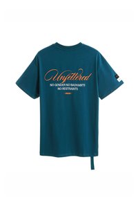 Camiseta de algodón en color azul verdoso con mangas cortas. Presenta "Unfettered" en cursiva y texto abajo. Incluye un detalle de lazo lateral.