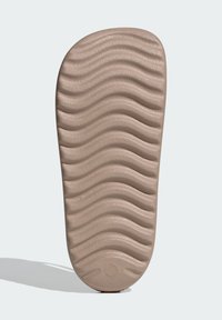 Bežová gumová podrážka so zvlnenou textúrou, s jasnými drážkami pre lepšiu priľnavosť. Hladké okraje a zaoblený tvar na päte.