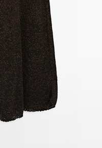 Maglione lavorato a maglia nero e marrone con una vestibilità comoda, caratterizzato da un motivo testurizzato e orlo a onda. Tessuto leggero con maniche lunghe.