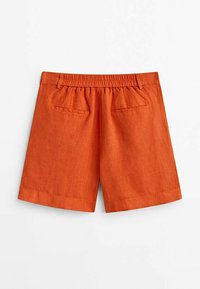 Shorts en lin orange rouille avec taille élastique, passants de ceinture et deux poches passepoilées à l'arrière sur un fond blanc.