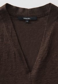 Top brown a V scollo realizzato in tessuto testurizzato. L'etichetta riporta "somday." con taglia 36. Focus sul scollo e sul design morbido e casual.