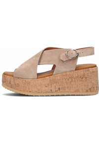 Sandales compensées en suedine beige avec une plateforme en liège, présentant un design à brides croisées et une sangle de cheville réglable avec une boucle en argent.