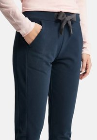 Marineblaue Sweatpants mit weicher Textur, ausgestattet mit einem Kordelzugbund, Seitentaschen und glatten Nähten für einen straffen Look.
