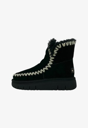 Stivaletti neri in suede, con cuciture bianche, rivestimento in pelliccia texturizzata e una spessa suola in gomma nera, con un piccolo logo sul lato.