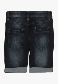 Pantalones cortos de mezclilla oscura, con un dobladillo enrollado, dos bolsillos traseros con acentos cosidos y un ligero desgaste. La cintura tiene presillas para cinturón.