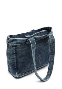 Denimtygväska i mörkblått, med förstärkta sömmar, en enkel axelrem och en dragkedjeficka längs toppen för säker stängning.