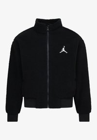 Veste en polaire noire avec col haut, fermeture éclair intégrale, poignets élastiques et ourlet côtelé. Logo brodé blanc notable sur la poitrine.