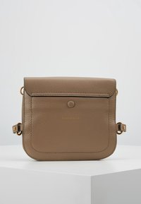 Bolso bandolera de cuero marrón con acabado texturizado, con cierre de solapa, detalle de botón redondo y herrajes en tono dorado.