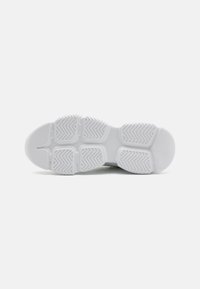 White sneaker sole with textured rubber. Features patterned grooves for traction and a smooth rounded toe area.