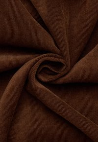 Donkerbruine corduroy stof met een geribbelde textuur, die plooien en een zachte afwerking toont, geschikt voor meubelstof of kleding.