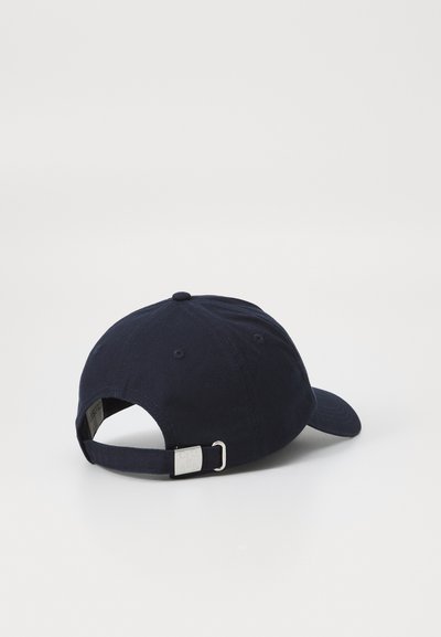 Marineblå bomulls baseballcaps med buet visir, justerbar stropp bak, og sydd øyeåpninger på toppen for ventilasjon.