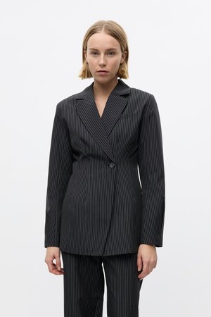 Schwarz gestreifter Blazer, tailliert geschnitten, mit zwei Knöpfen, Reverskragen, einer Brusttasche, glatte Textur, getragen mit passenden Hosen.
