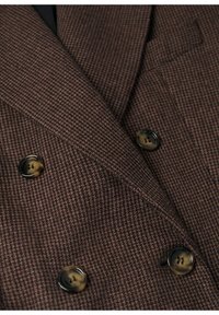 Bruine houndstooth dubbelgeknoopte blazer met grote zwarte en schildpadknopen, gestructureerde stof en scherpe revers.