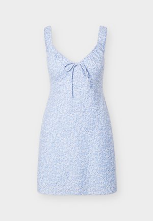 Jasnoniebieska sukienka bez rękawów z drobnym białym kwiatowym wzorem i wiązaniem z przodu na dekolcie z zaokrąglonym wycięciem, prezentowana na jednolitym tle.