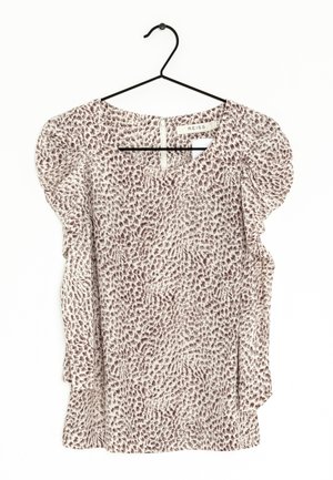 Lekkia bluzka z bufkami, z beżowym tłem i brązowym, abstrakcyjnym wzorem zwierzęcym. Okrągły dekolt, zamek błyskawiczny z tyłu.