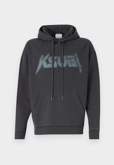 Tumšas pelēkas kapuces krūšturis ar priekšējo kangarū poku. Iespējots liels, nolietots grafiskais logotips zilā krāsā uz krūšu daļas.