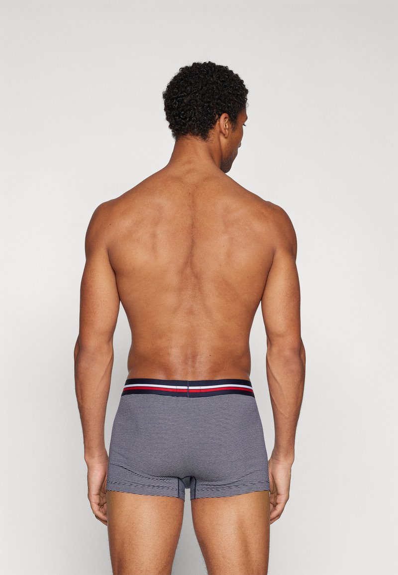 Grau gestreifte Boxershorts mit taillierter Passform und einem kontrastierenden rot-blauen Bund, von hinten betrachtet. Glatte Stoffoberfläche.