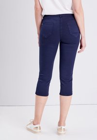 Marineblauwe capri-broeken gemaakt van rekbare katoenmix, met achterzakken en een getailleerd ontwerp, die net onder de kuit eindigen.