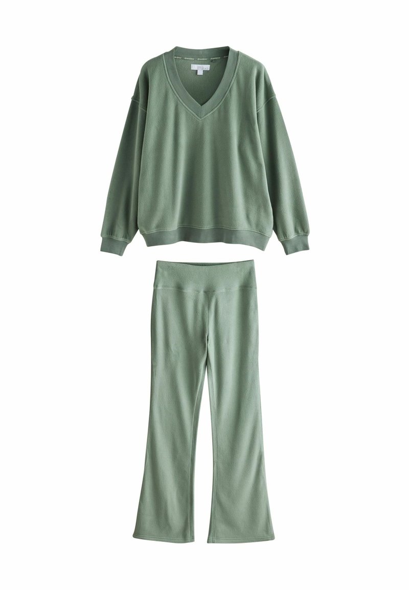 Grøn pullover med V-hals og lange ærmer, parret med matchende flared bukser. Begge lavet af blød, struktureret stof.