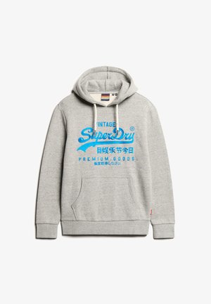 Felpa grigia con cappuccio caratterizzata da una grande stampa grafica blu con la scritta "SuperDry" e caratteri giapponesi. Include una tasca frontale e un cappuccio regolabile con cordino.