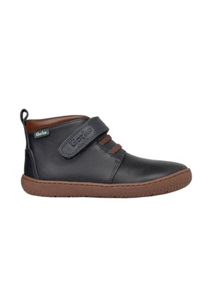 Zapato infantil de cuero negro con suela marrón, cuello marrón y tira de Velcro etiquetada "Gorila."