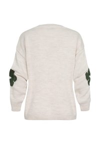 Cream knit sweater featuring a textured finish, drop shoulder design, and green floral pattern accents on the elbows.