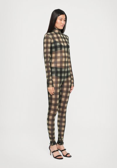 Sheer, fitted bodysuit with a plaid pattern in black, brown, and beige. High neck, long sleeves, paired with black strappy heels.