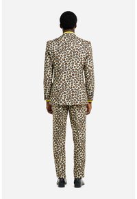 Leopardenmuster-Anzug in Beige und Braun, mit tailliertem Design, passenden Hosen und einem dezenten gelben Akzent am Kragen.