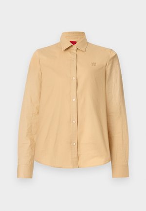 Beige langærmet skjorte med knapper, blødt bomuldsstof, standard krave, med et broderet logo på brystet og knaplukning foran.