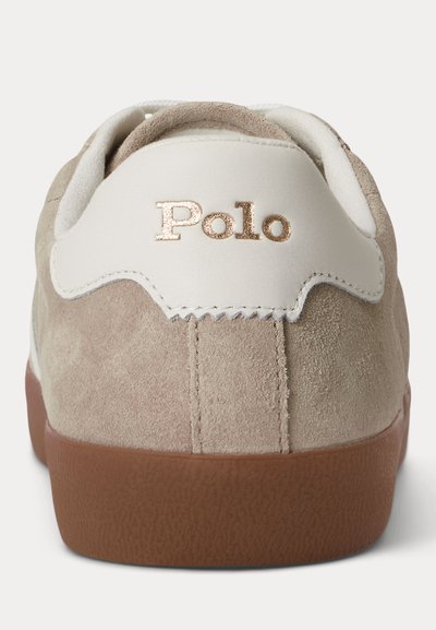 Τακούνι αθλητικού παπουτσιού από μπεζ σουέτ με καφέ λαστιχένια σόλα, λευκή λεπτομέρεια στο γιακά, και λογότυπο "Polo" σε μεταλλικά γράμματα στο πίσω μέρος.