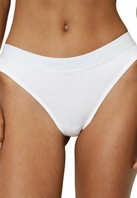 Mutande bikini in cotone bianco con un morbido elastico in vita e una leggera scritta in rilievo, che offrono un design minimalista e senza cuciture.